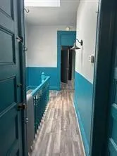a view of a hallway with wooden floor and chandelier