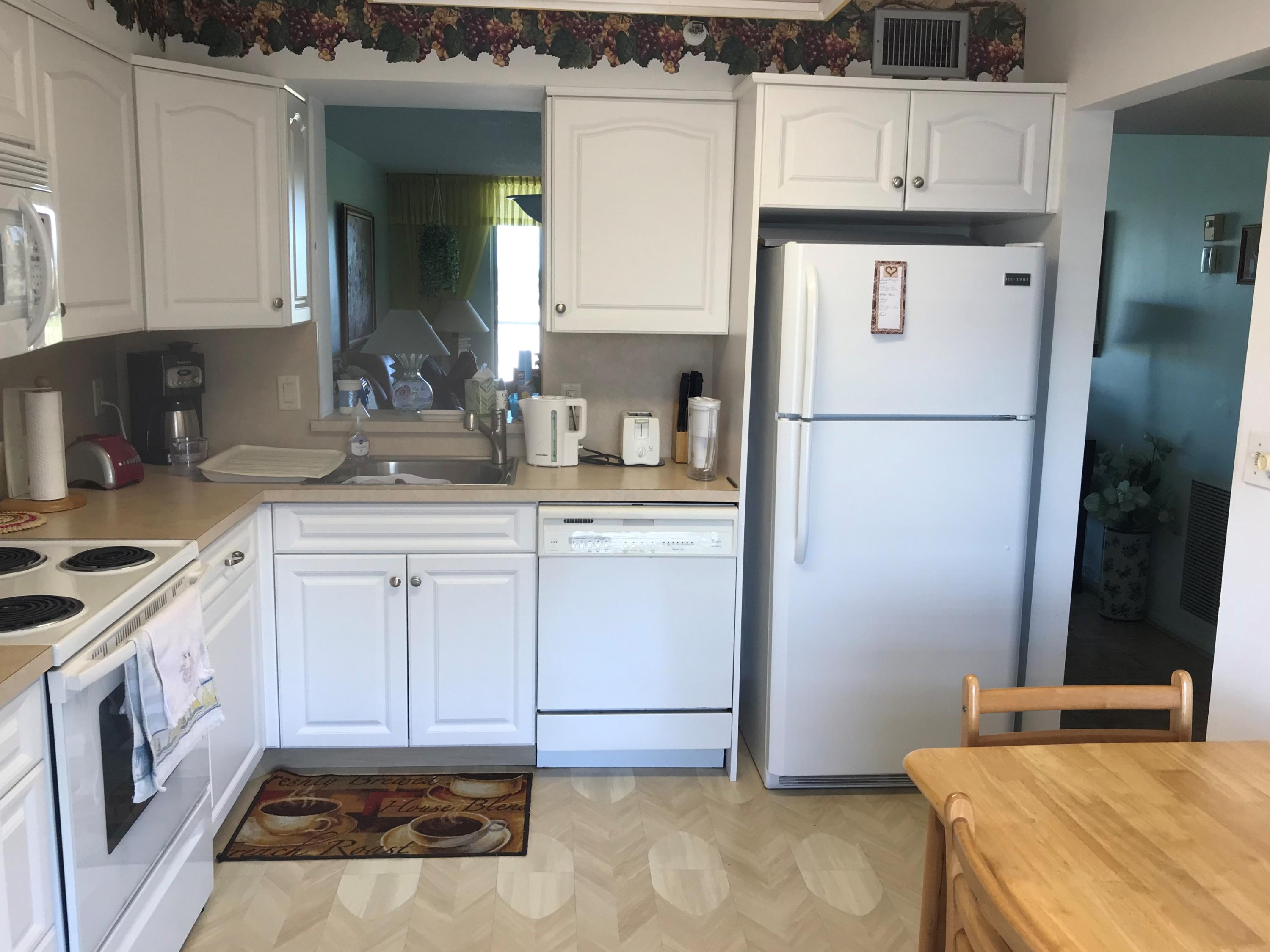 a kitchen with a sink a stove a refrigerator and cabinets