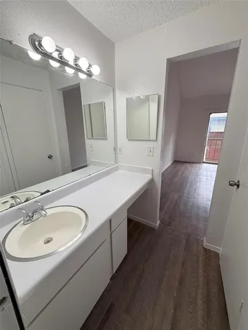 a bathroom with a sink a light fixture a mirror and a vanity