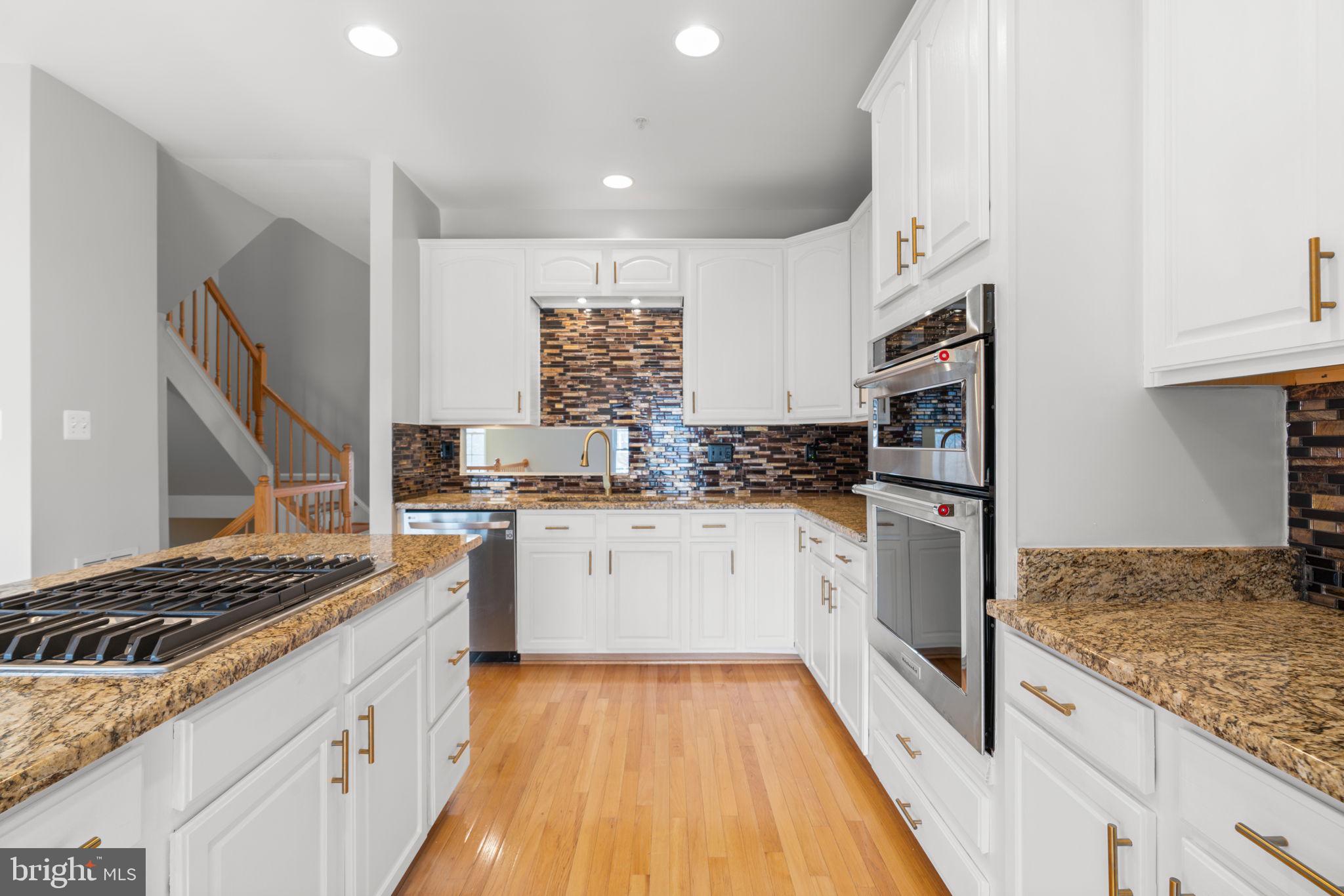 2475 Jostaberry Way Odenton, MD 21113 - Photo 11 of 53 a kitchen with granite countertop a sink stove and cabinets