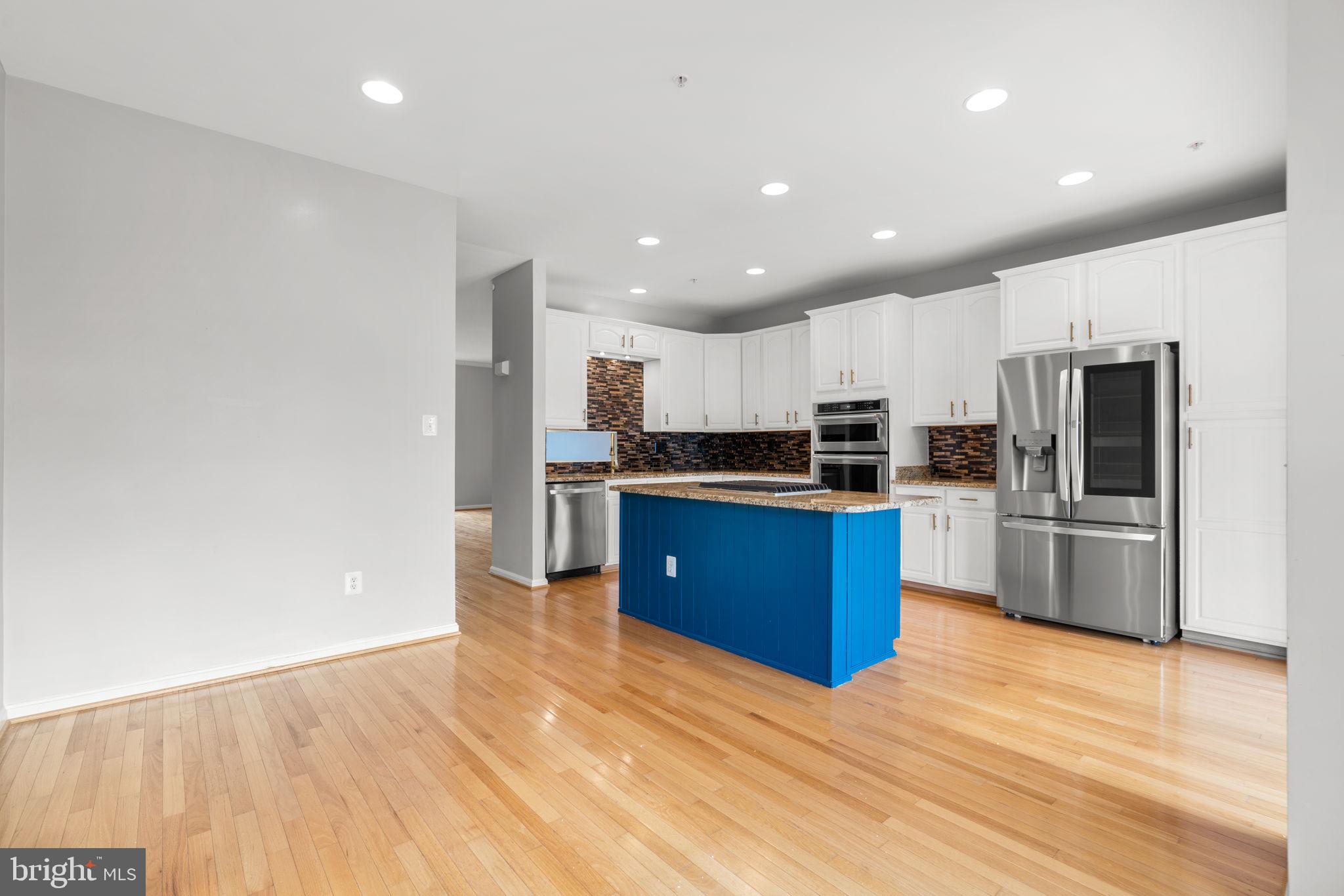 2475 Jostaberry Way Odenton, MD 21113 - Photo 16 of 53 a kitchen with stainless steel appliances granite countertop a stove a refrigerator a sink a microwave oven with wooden floor