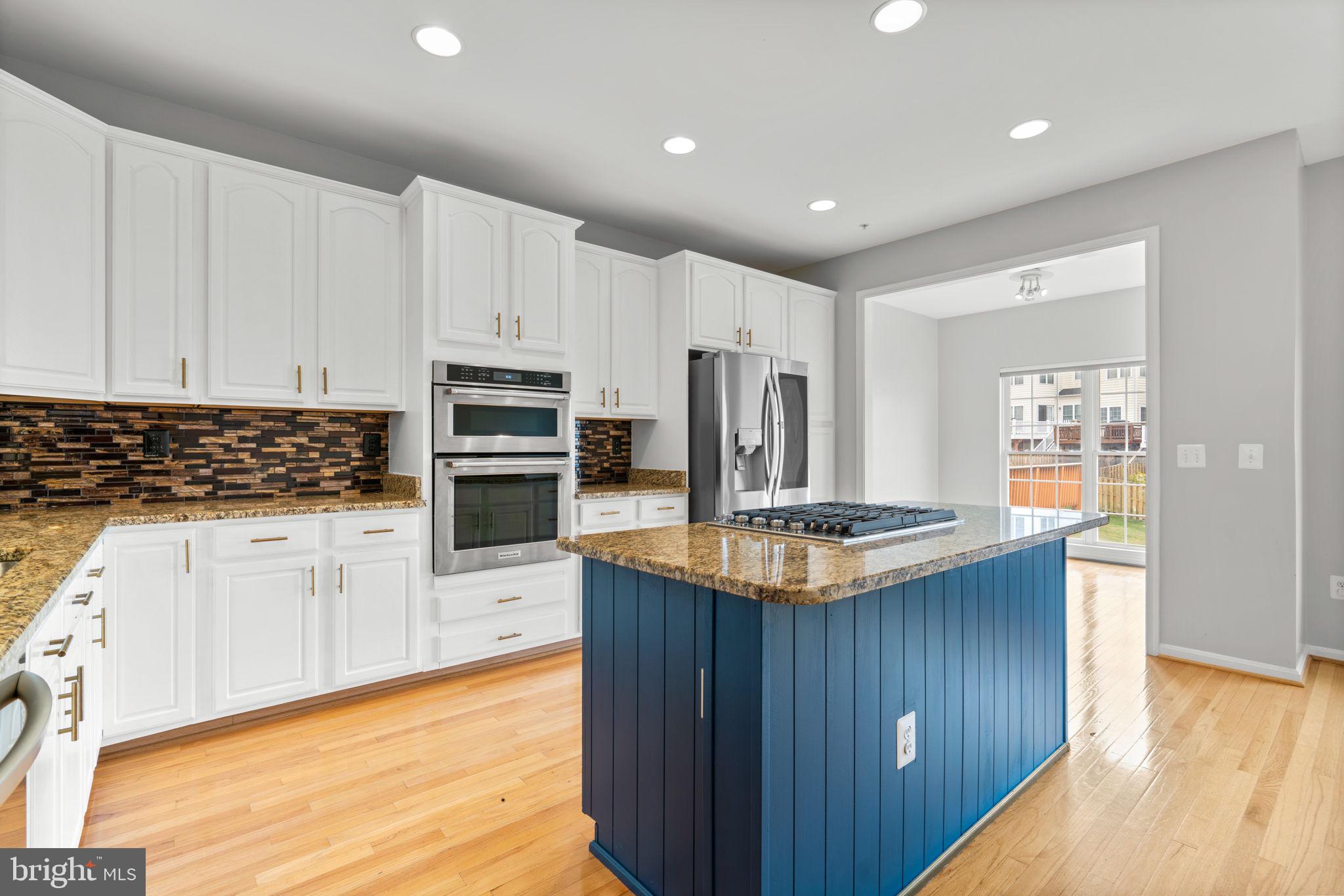 2475 Jostaberry Way Odenton, MD 21113 - Photo 8 of 53 a kitchen with kitchen island granite countertop a stove and a wooden floors