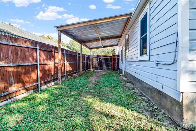 a view of a backyard with wooden fence