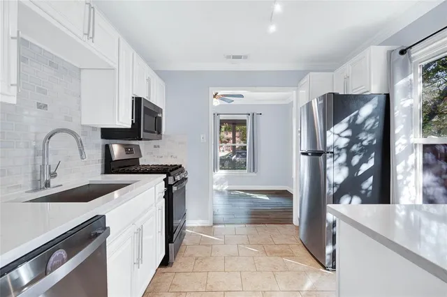a kitchen with granite countertop a sink and a stove top oven with wooden floor
