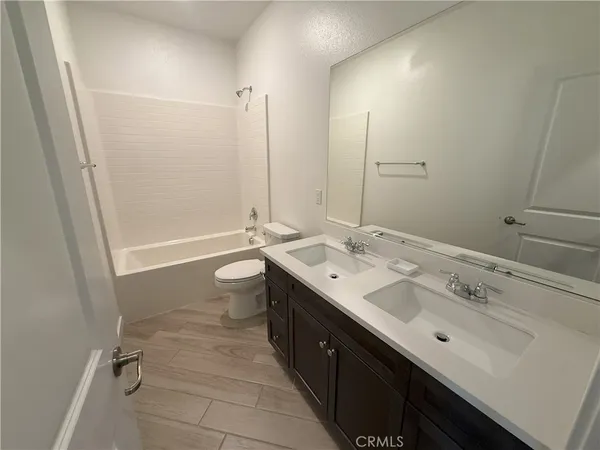 a bathroom with a double vanity sink mirror double and toilet