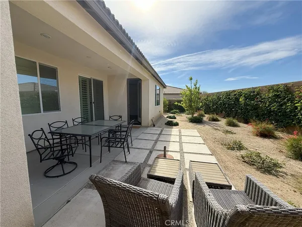 a view of a patio with table and chairs with wooden floor and fence
