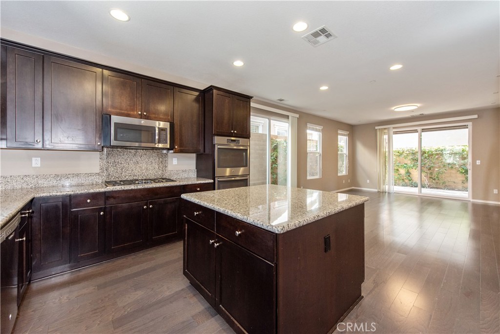 148 Compass Irvine, CA 92618 - Photo 5 of 26 a kitchen with kitchen island granite countertop a sink counter top space and stainless steel appliances