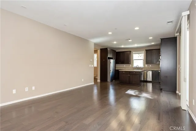 a view of kitchen with refrigerator stove and wooden floor