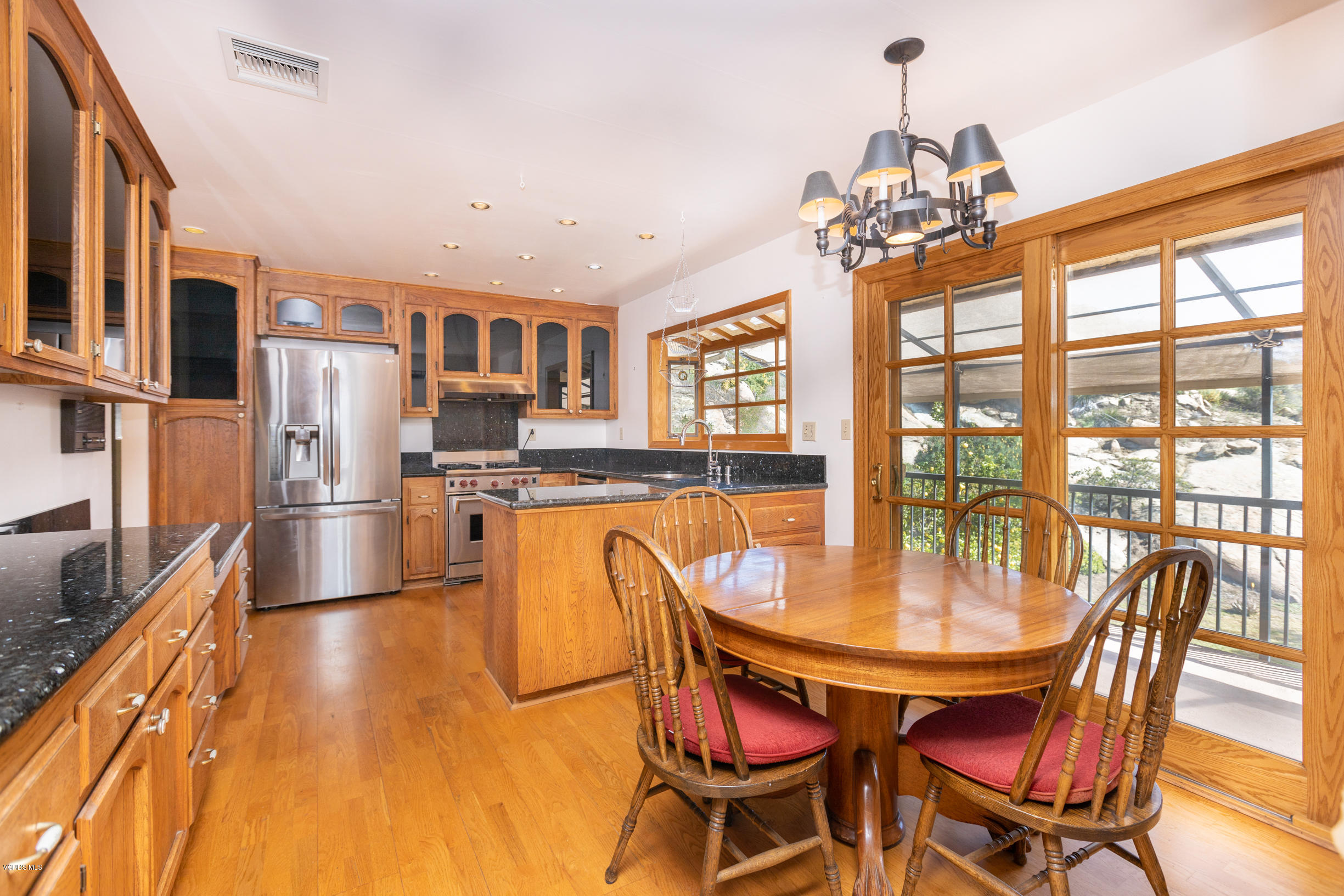 7240 Studio Road Canoga Park, CA 91304 - Photo 6 of 19 a dining room with furniture a chandelier and wooden floor