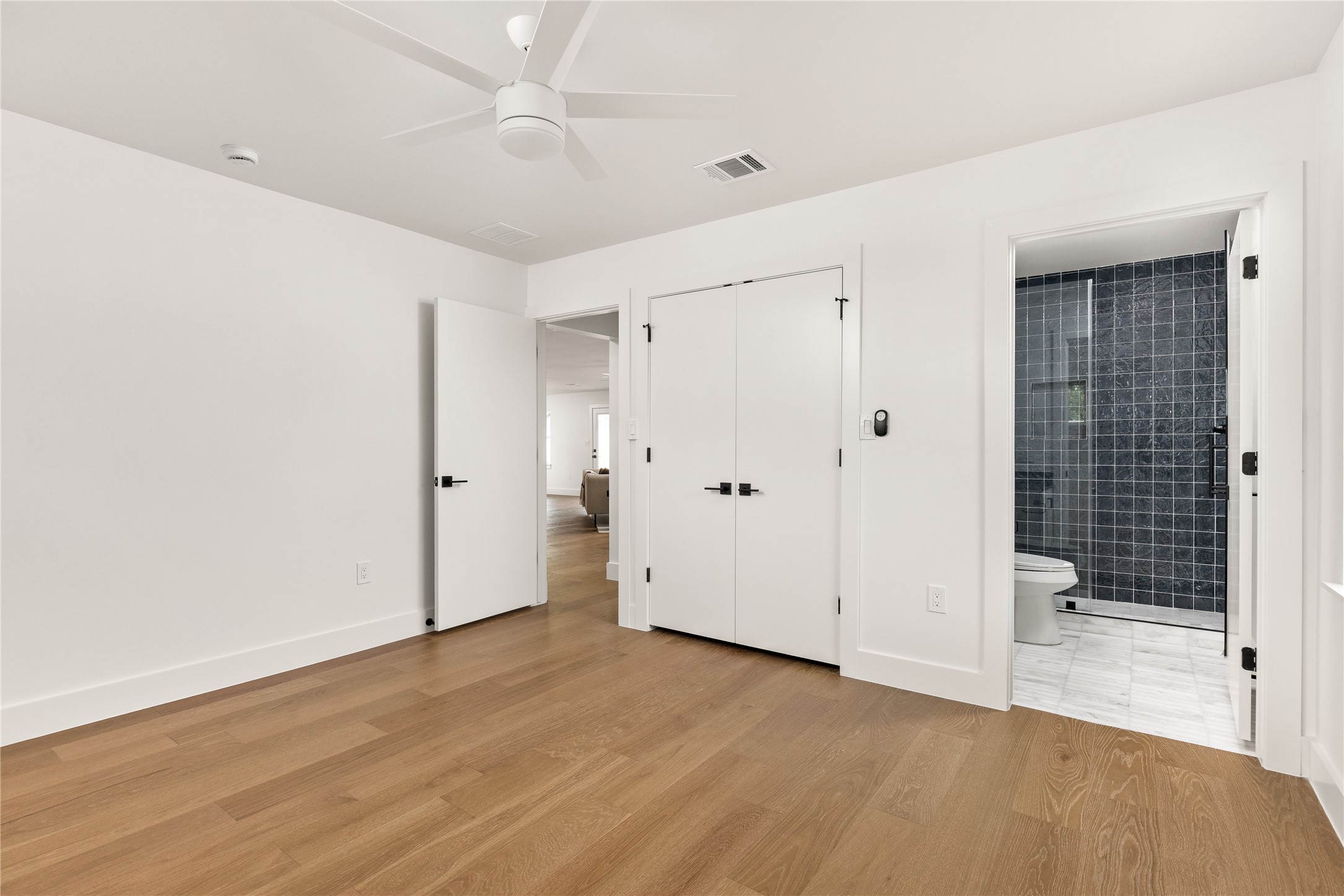 4501 Pack Saddle Pass Austin, TX 78745 - Photo 27 of 37 Room featuring wood-finish flooring, a white ceiling fan, and white baseboards