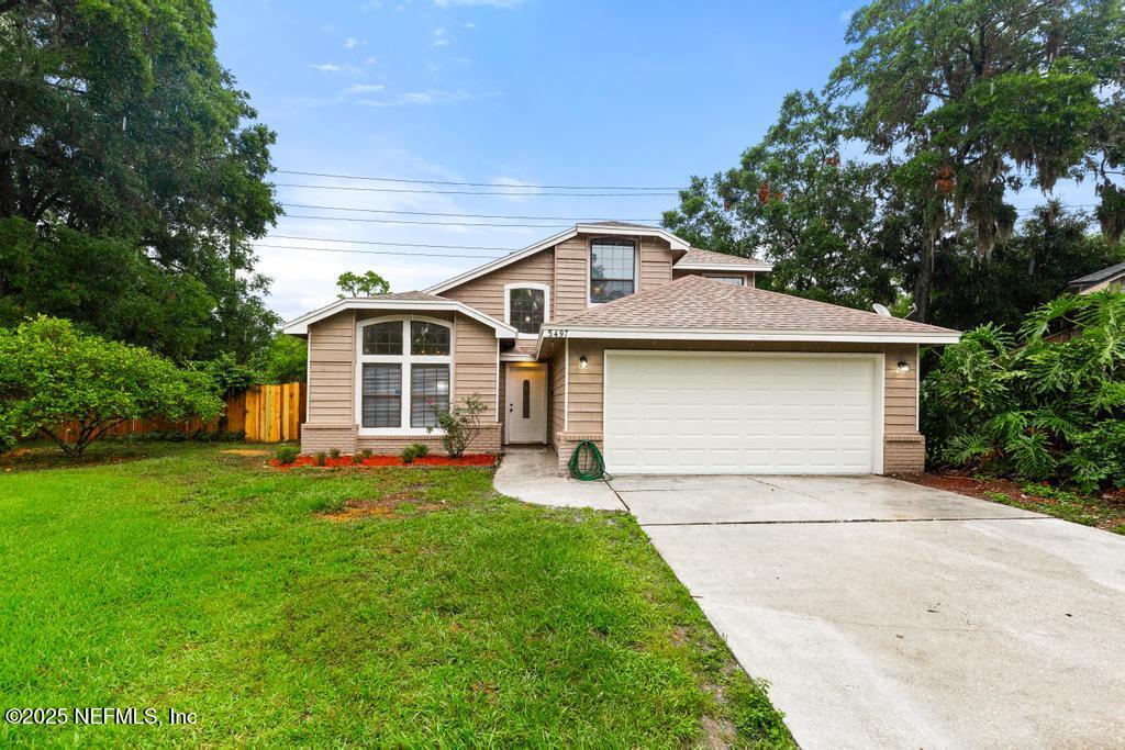 a front view of house with yard and green space