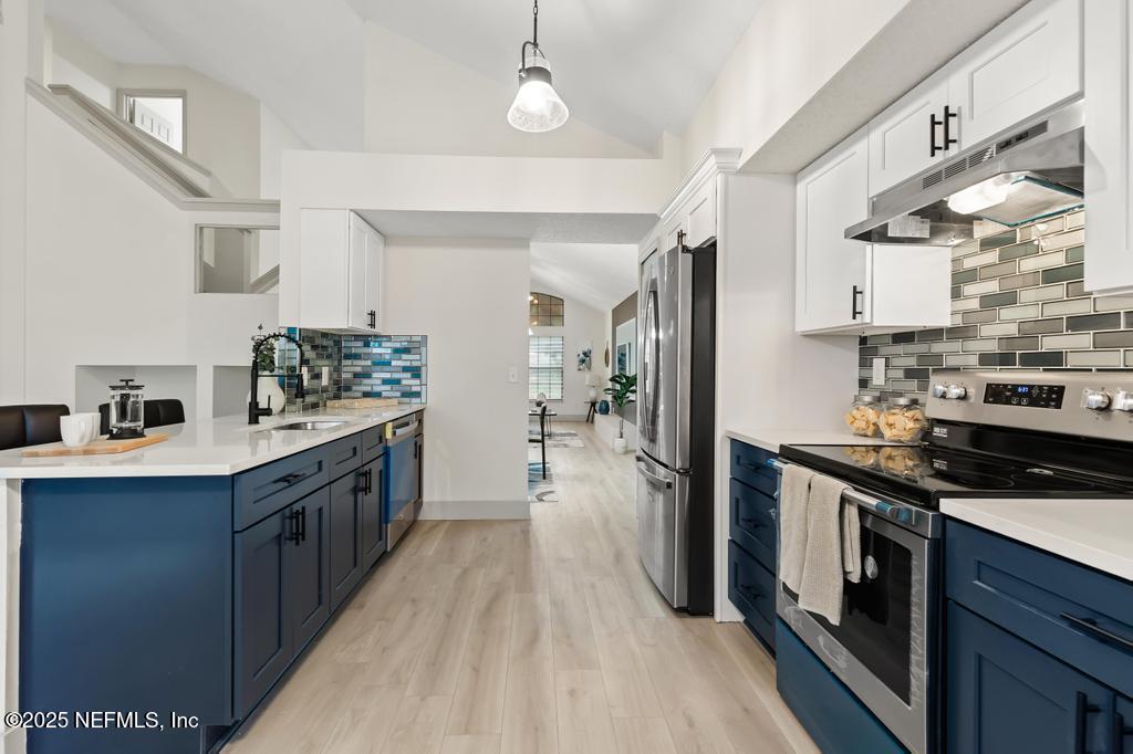 5497 Spring Brook Road Jacksonville, FL 32277 - Photo 15 of 54 a kitchen with stainless steel appliances granite countertop a stove a sink dishwasher a refrigerator and a oven with wooden floor