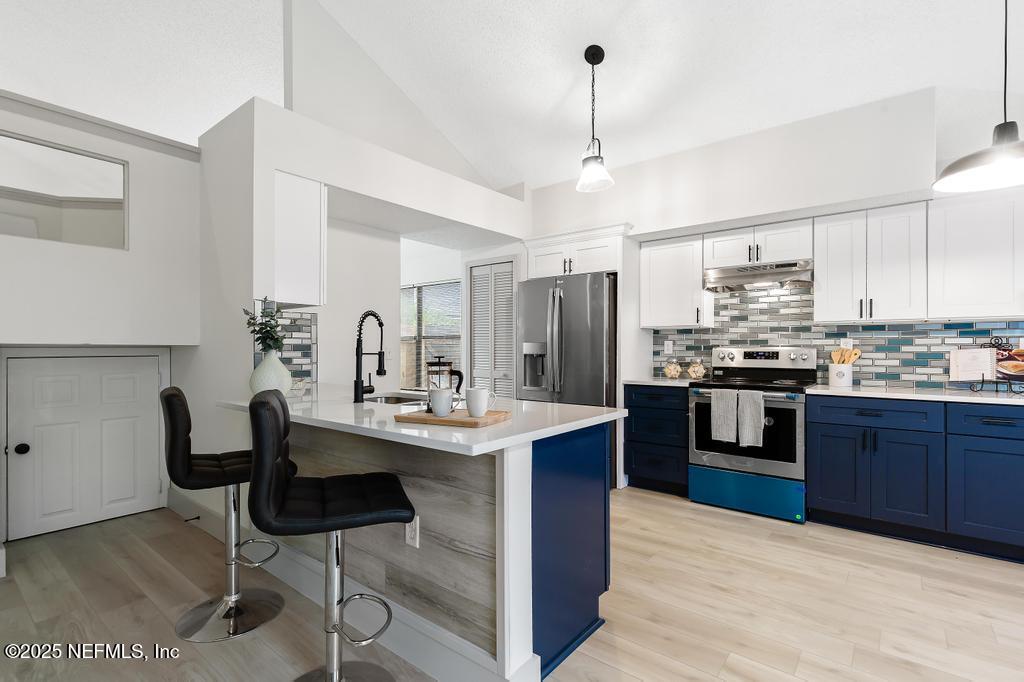 5497 Spring Brook Road Jacksonville, FL 32277 - Photo 17 of 54 a kitchen with stainless steel appliances kitchen island granite countertop a sink refrigerator and cabinets