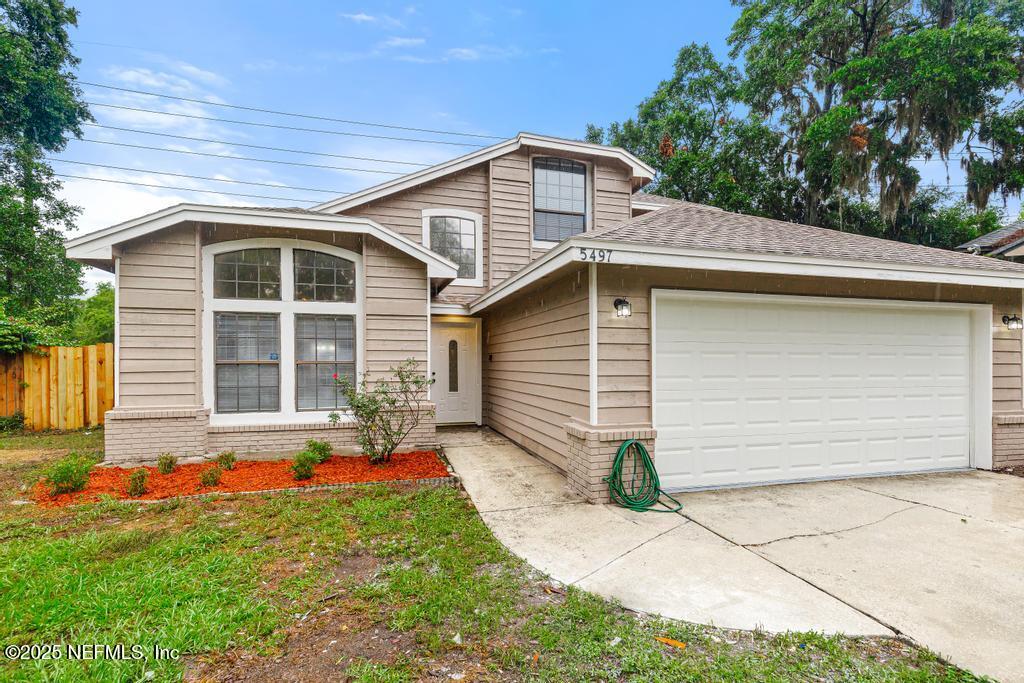 5497 Spring Brook Road Jacksonville, FL 32277 - Photo 2 of 54 a front view of a house with a yard and garage