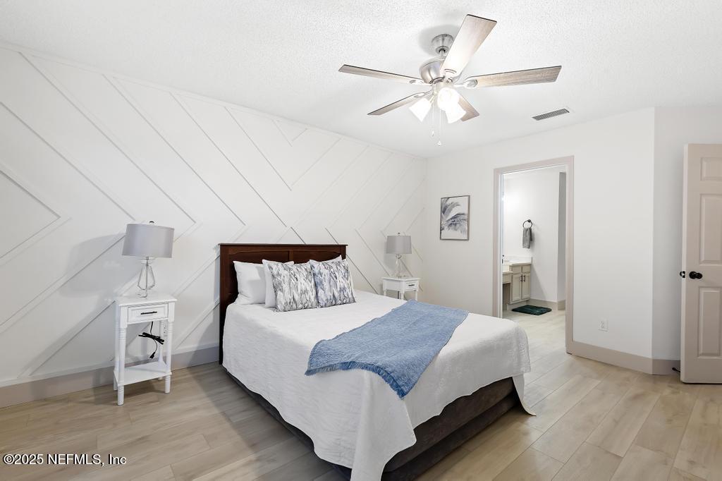 5497 Spring Brook Road Jacksonville, FL 32277 - Photo 23 of 54 a spacious bedroom with a bed and a chandelier