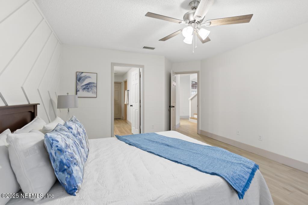 5497 Spring Brook Road Jacksonville, FL 32277 - Photo 24 of 54 a bedroom with a large bed and a chandelier