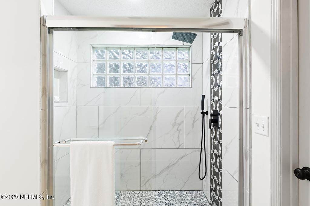 5497 Spring Brook Road Jacksonville, FL 32277 - Photo 29 of 54 a bathroom with a window and a shower