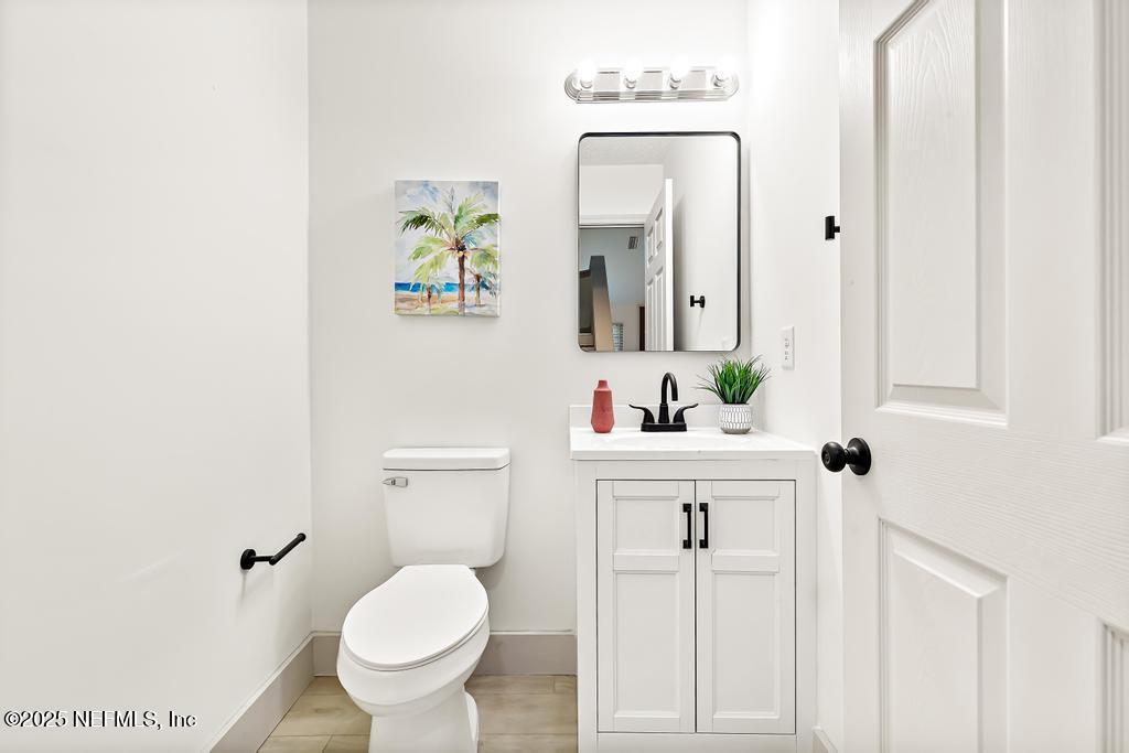 5497 Spring Brook Road Jacksonville, FL 32277 - Photo 30 of 54 a bathroom with a toilet sink and mirror