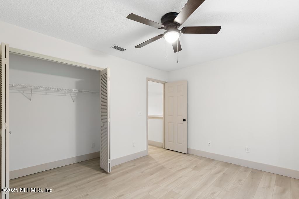 5497 Spring Brook Road Jacksonville, FL 32277 - Photo 42 of 54 an empty room with ceiling fan and window