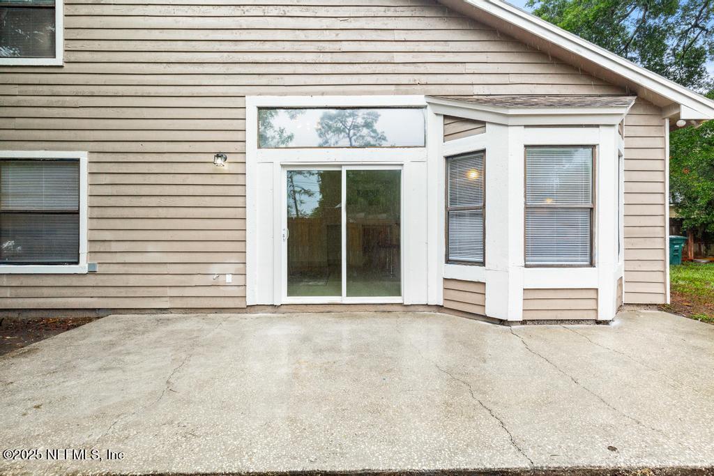 5497 Spring Brook Road Jacksonville, FL 32277 - Photo 47 of 54 a view of a house with a door and a large window