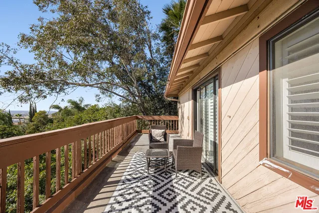 a view of a balcony with wooden floor and fence