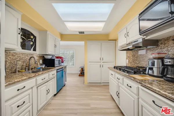 a large kitchen with stainless steel appliances granite countertop a stove and a sink