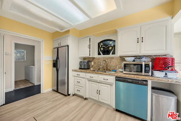a kitchen with stainless steel appliances granite countertop a refrigerator and a stove top oven
