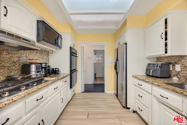 a large kitchen with cabinets stainless steel appliances and a counter space