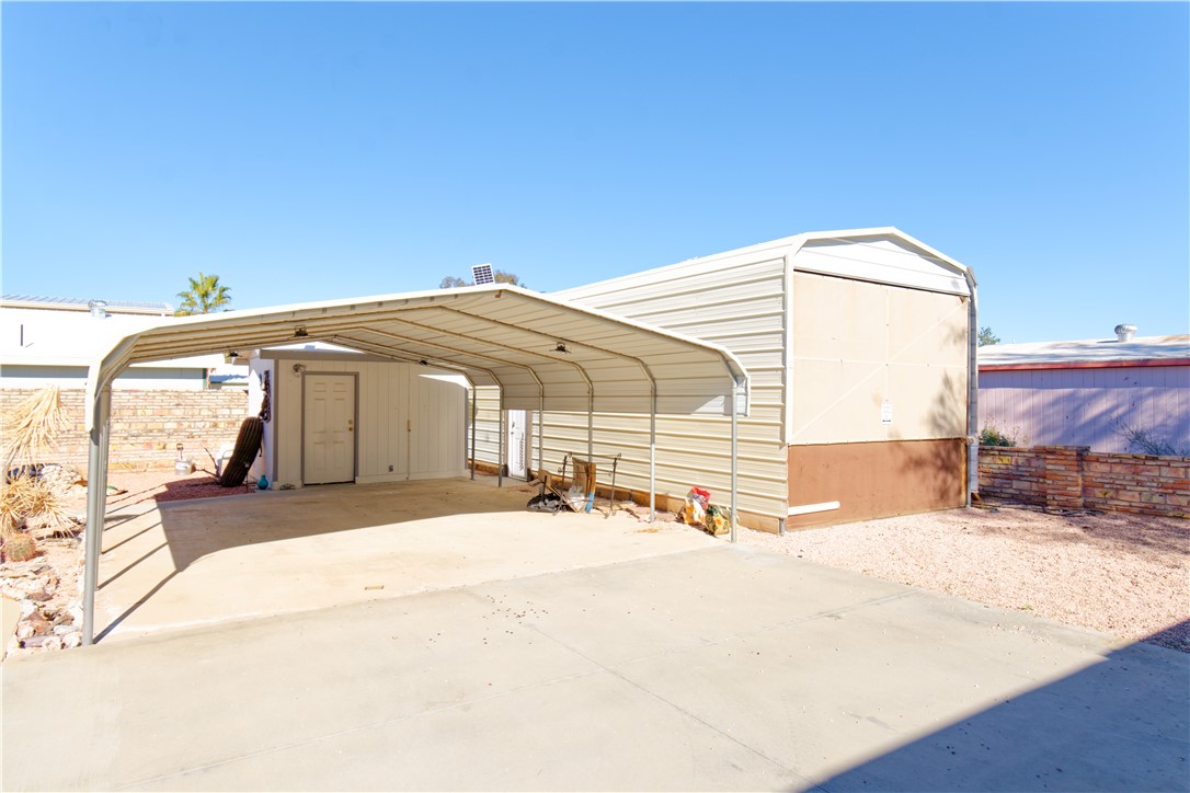 49603 Rainbow Avenue Quartzsite, AZ 85346 - Photo 2 of 44 View of parking with a carport, a shed, and concrete driveway