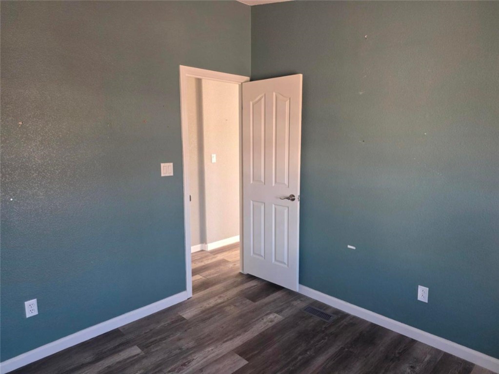 49603 Rainbow Avenue Quartzsite, AZ 85346 - Photo 19 of 44 Empty room with dark wood-style floors and baseboards