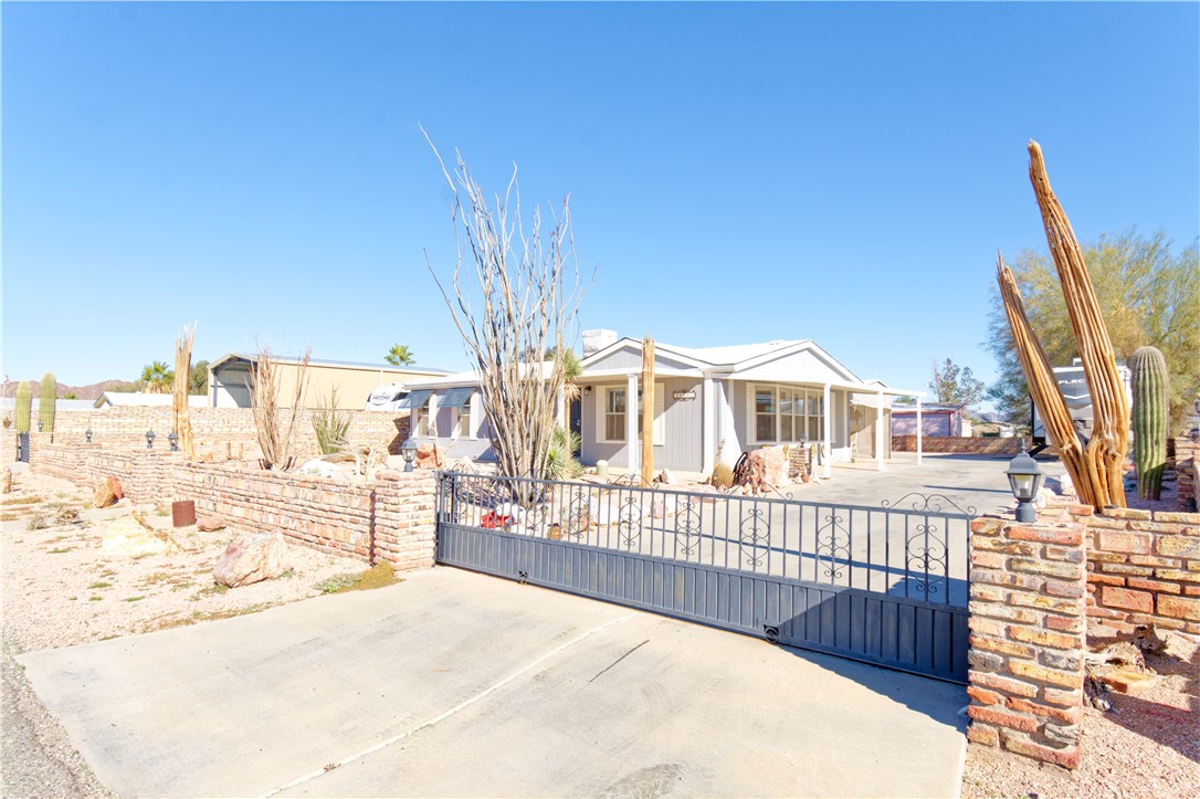 49603 Rainbow Avenue Quartzsite, AZ 85346 - Photo 28 of 44 View of front of home featuring a gate, a fenced front yard, and a patio