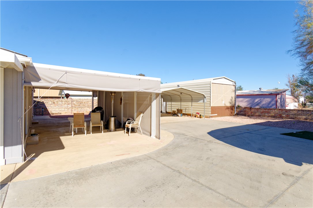 49603 Rainbow Avenue Quartzsite, AZ 85346 - Photo 34 of 44 View of patio featuring driveway, a detached carport, and a shed