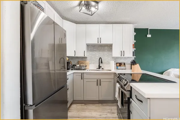 a kitchen with a sink a refrigerator and cabinets