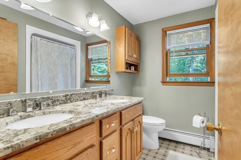 87 Cote Road Monson, MA 01057 - Photo 16 of 30 a bathroom with a granite countertop sink toilet a large mirror and a window