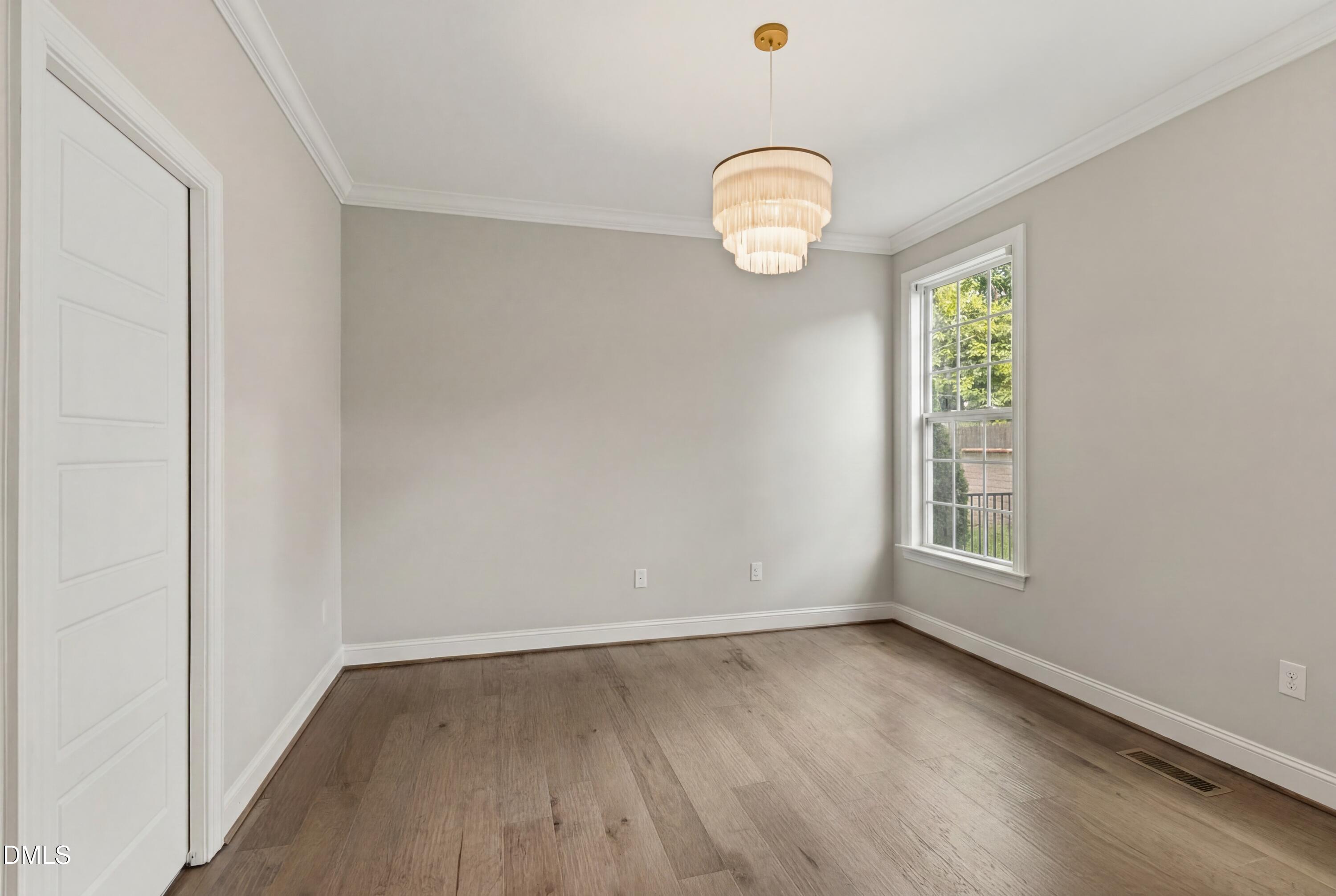 7421 Stonehenge Farm Lane Raleigh, NC 27613 - Photo 33 of 48 an empty room with wooden floor and windows