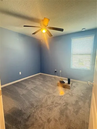 an empty room with a window and a fan