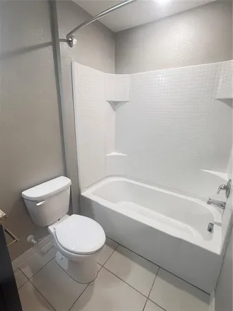 a white toilet and tub sitting next to a bathroom sink
