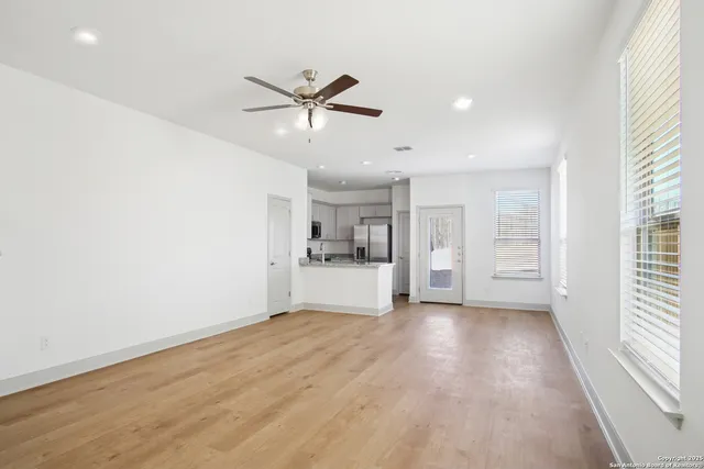 a view of empty room with wooden floor and window