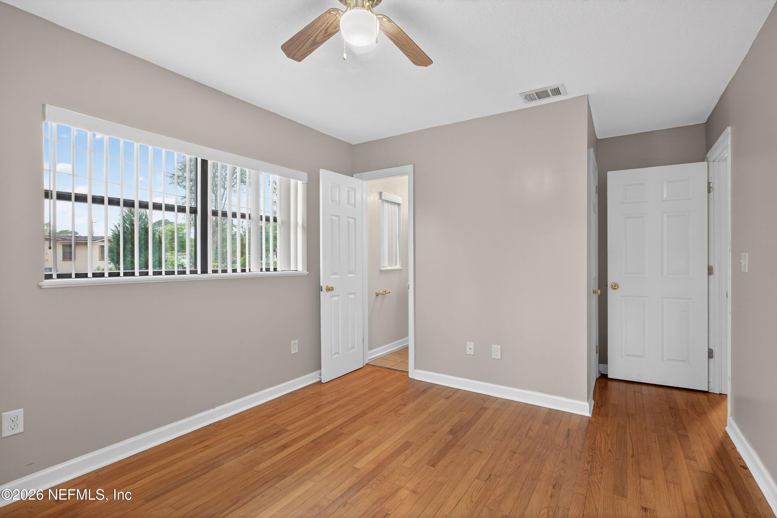 4231 Rendale Drive North Jacksonville, FL 32210 - Photo 16 of 37 a view of an empty room with wooden floor and a window