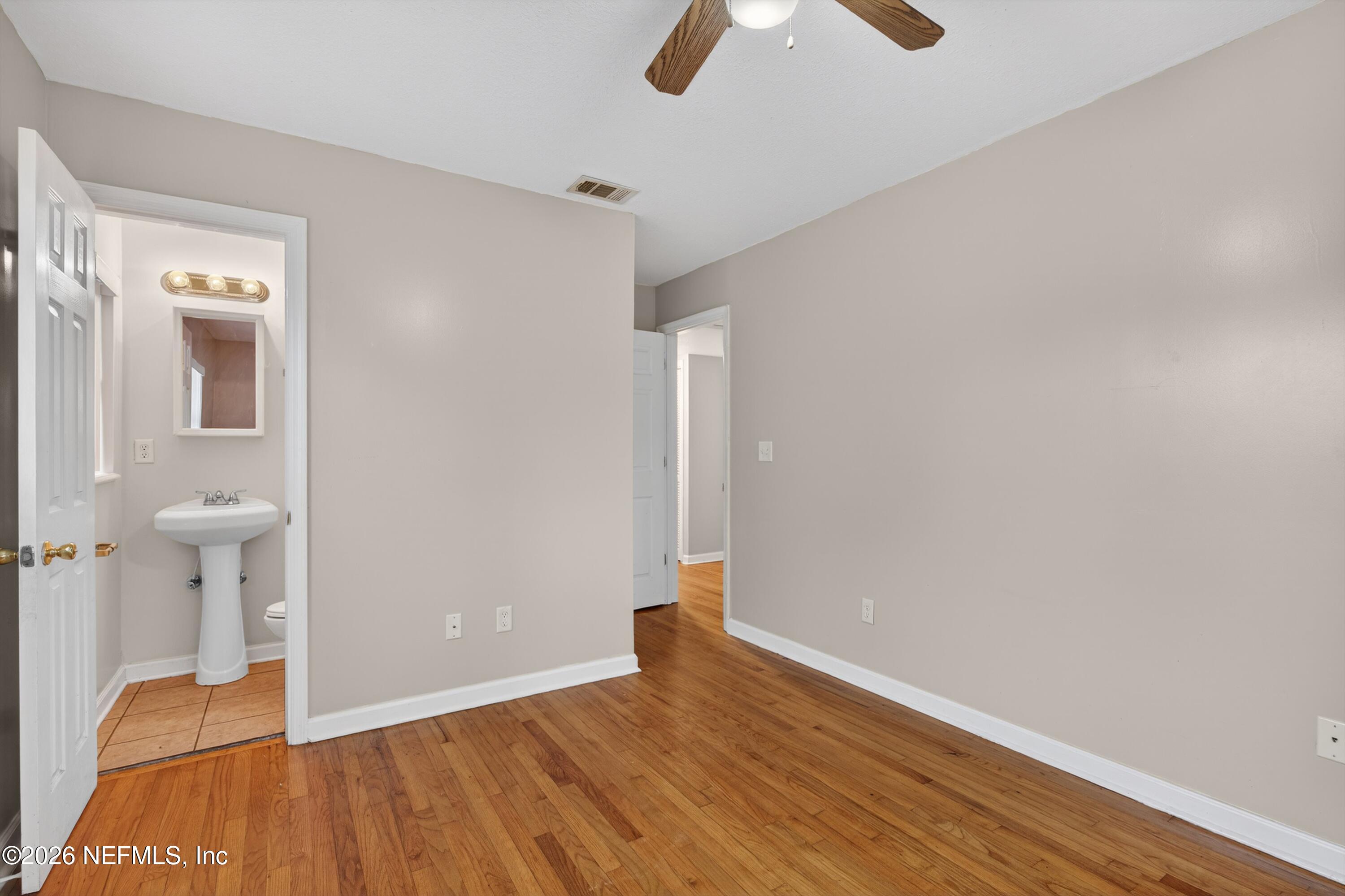 4231 Rendale Drive North Jacksonville, FL 32210 - Photo 17 of 37 an empty room with wooden floor and windows