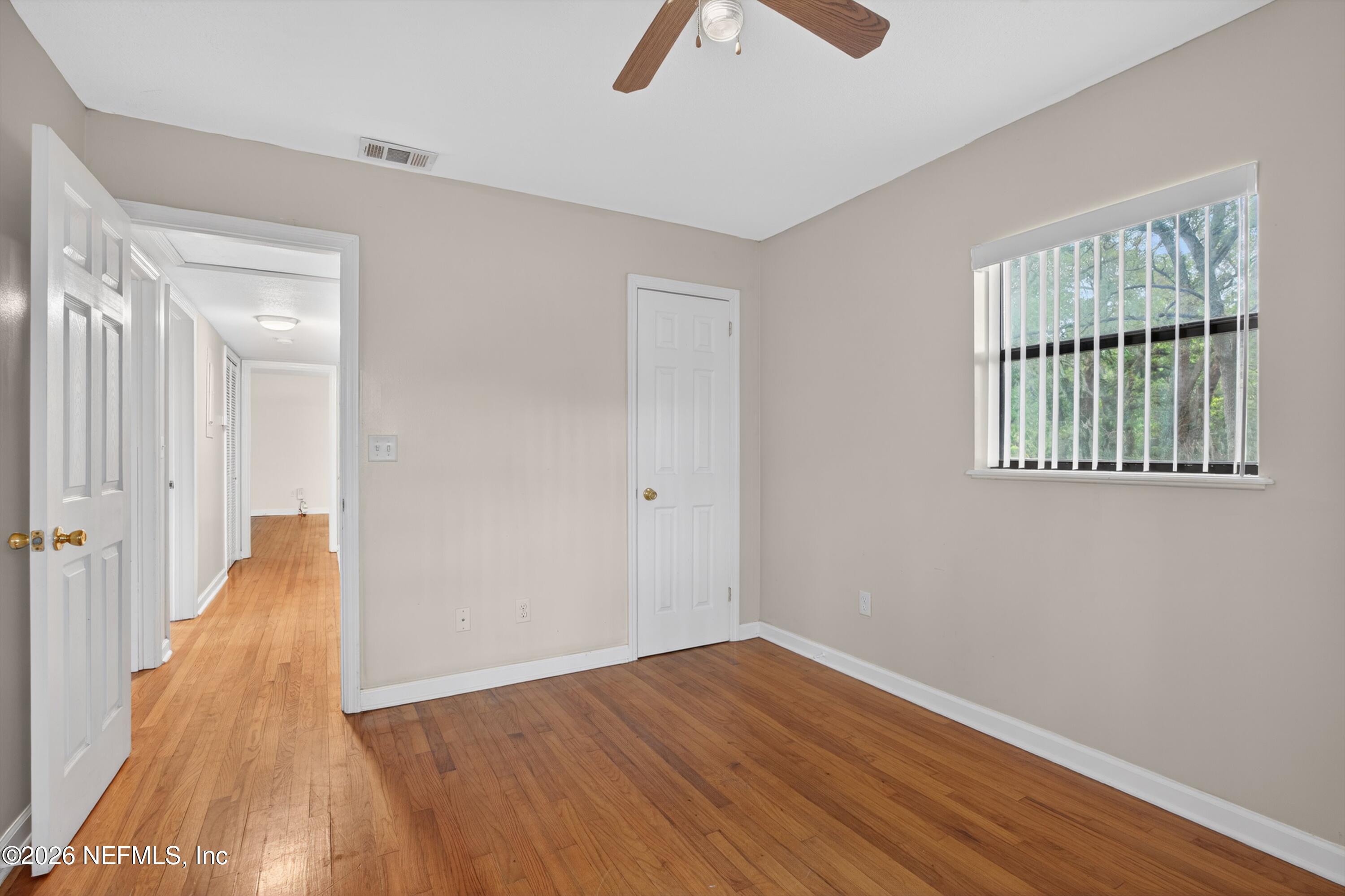 4231 Rendale Drive North Jacksonville, FL 32210 - Photo 22 of 37 wooden floor in an empty room with a window