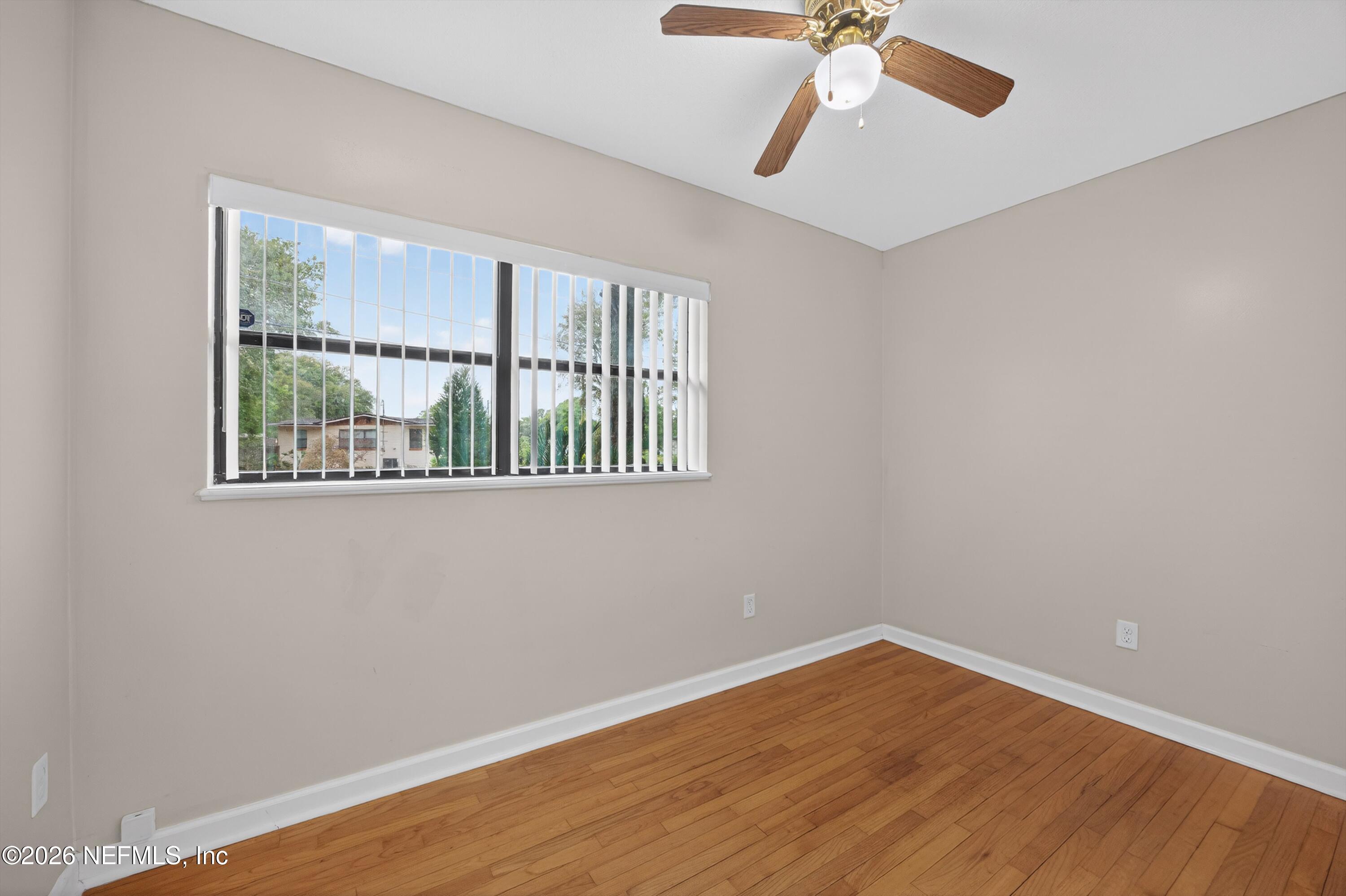 4231 Rendale Drive North Jacksonville, FL 32210 - Photo 26 of 37 a view of an empty room with wooden floor and a window