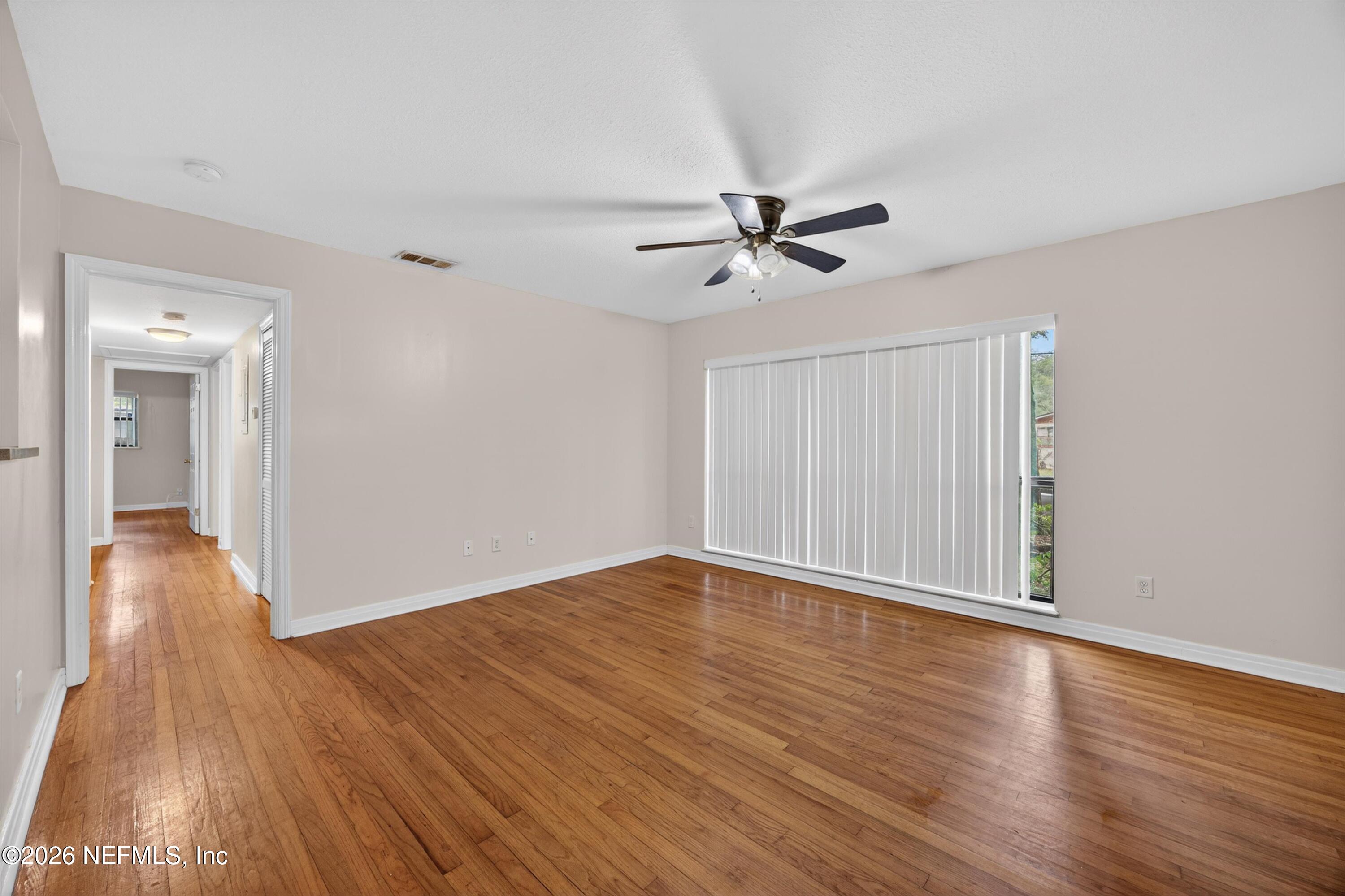 4231 Rendale Drive North Jacksonville, FL 32210 - Photo 6 of 37 a view of empty room with wooden floor and ceiling fan