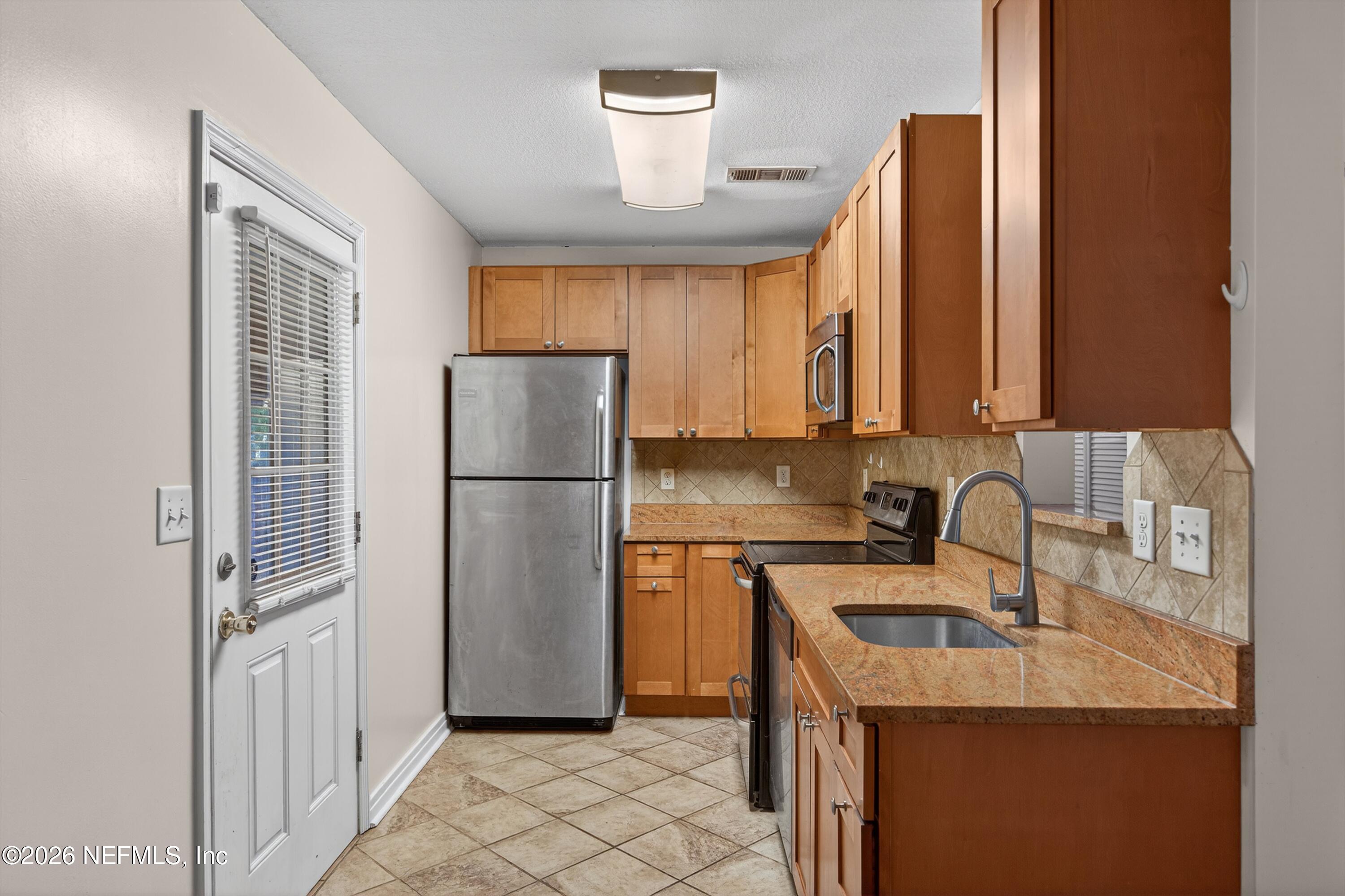4231 Rendale Drive North Jacksonville, FL 32210 - Photo 10 of 37 a kitchen with stainless steel appliances granite countertop a refrigerator a sink and a stove