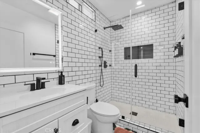 a bathroom with a sink a toilet and shower