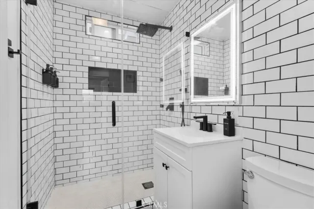 a bathroom with a sink a toilet and shower