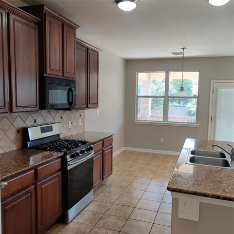 a kitchen with stainless steel appliances granite countertop a sink and stove
