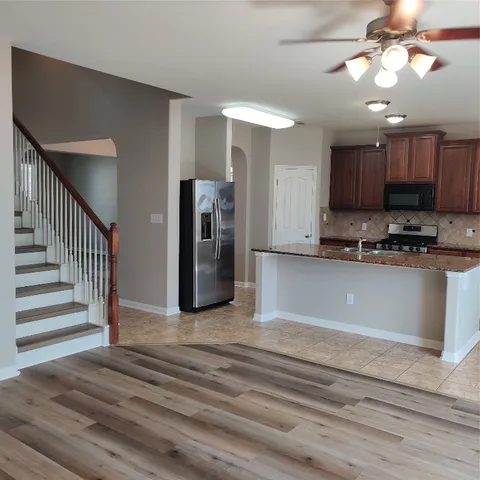 an empty room with a window and a fan