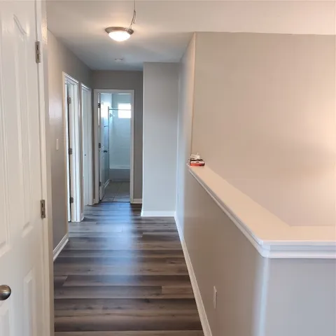 a view of entryway and hall with wooden floor