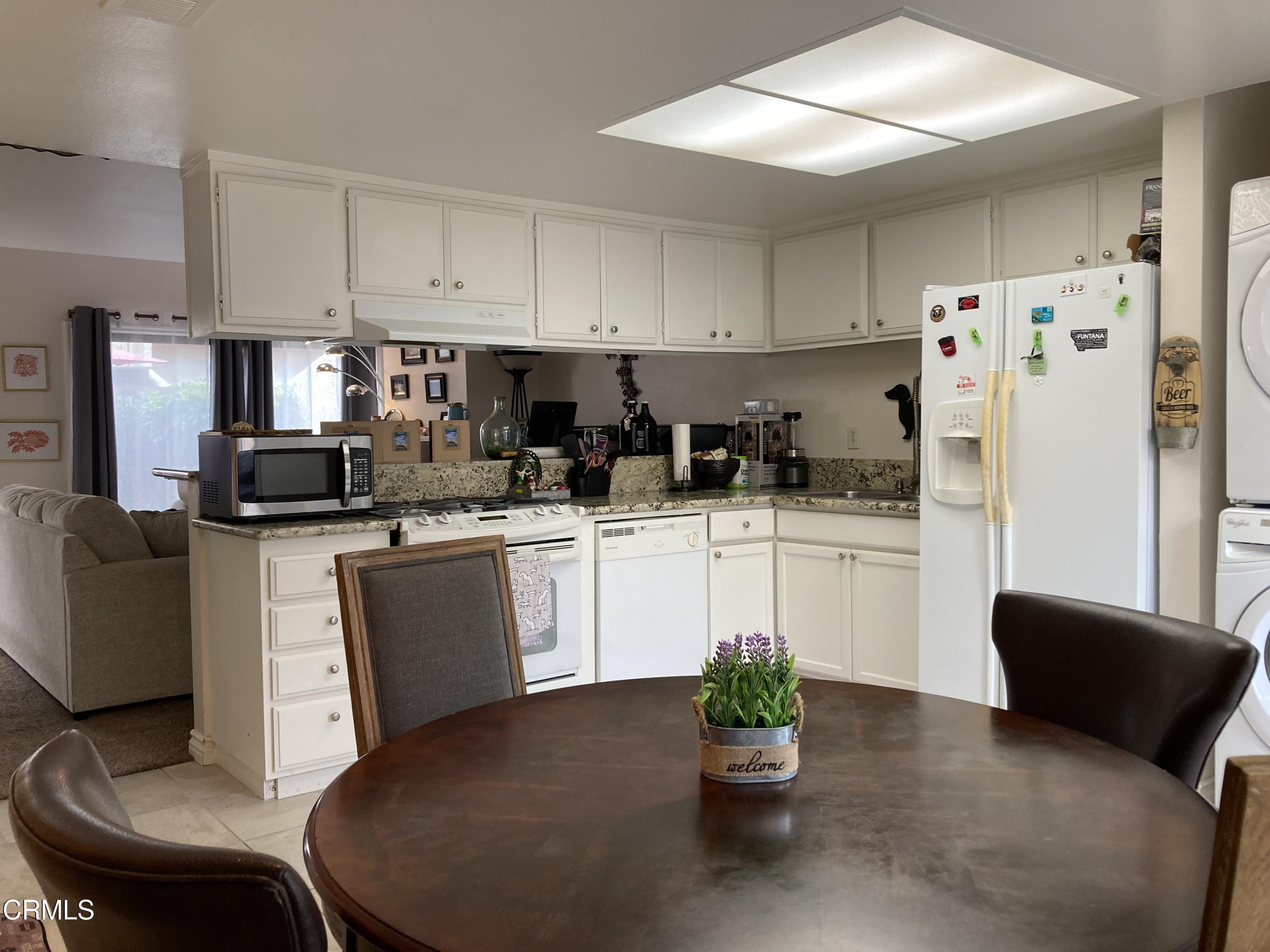 5130 West Wooley Road, Unit 2 Oxnard, CA 93035 - Photo 4 of 11 a kitchen with white cabinets and refrigerator